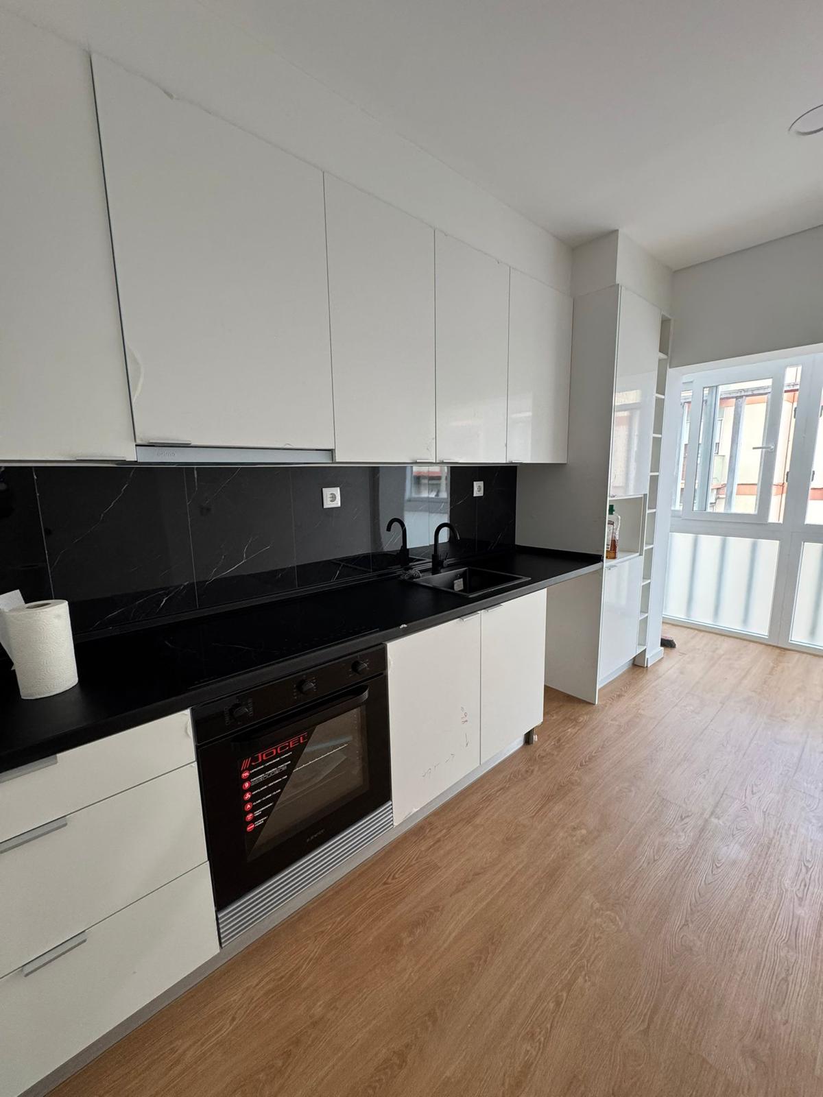 Cozinha branca com bancada e backsplash em mármore preto